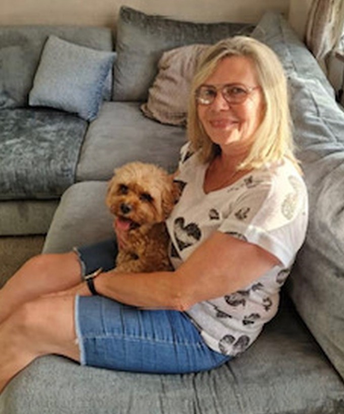 Amanda, owner of Tails ‘A’ Wagging, sitting at home with Oscar the cockapoo